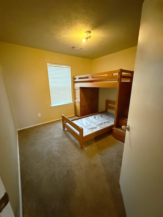 unfurnished bedroom featuring a textured ceiling and carpet flooring