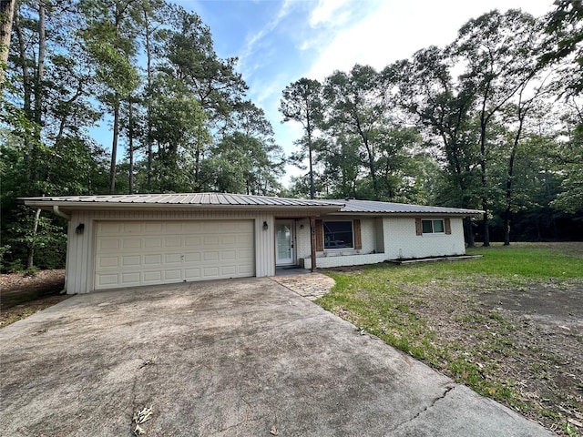 ranch-style house featuring board and batten siding, an attached garage, driveway, and metal roof