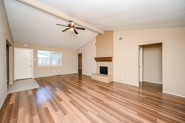 unfurnished living room with vaulted ceiling with beams, ceiling fan, light wood-type flooring, and a brick fireplace