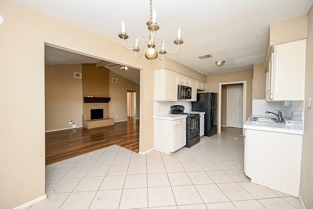 kitchen with sink, vaulted ceiling with beams, pendant lighting, white cabinets, and black appliances