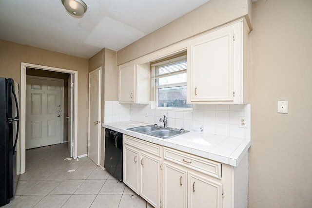 kitchen featuring tile counters, sink, backsplash, white cabinets, and black appliances