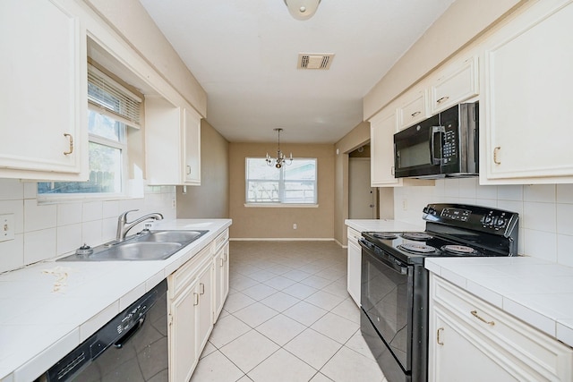 kitchen with white cabinetry, sink, a notable chandelier, pendant lighting, and black appliances