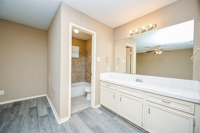 bathroom featuring ceiling fan, toilet, wood-type flooring, and vanity