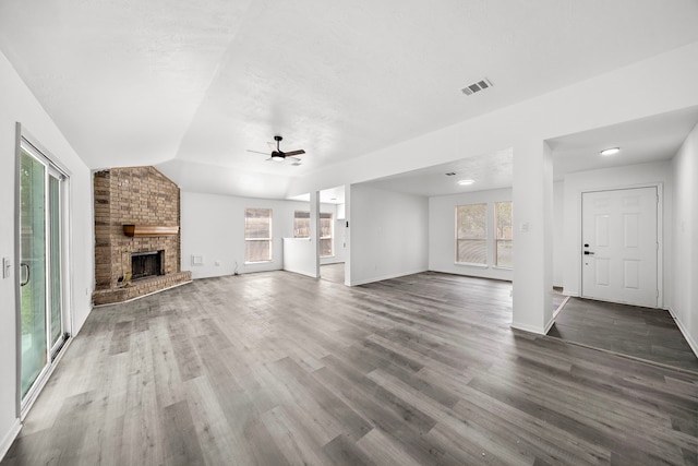 unfurnished living room with a fireplace, a healthy amount of sunlight, and vaulted ceiling