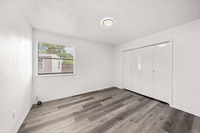 unfurnished bedroom featuring light hardwood / wood-style floors and a closet