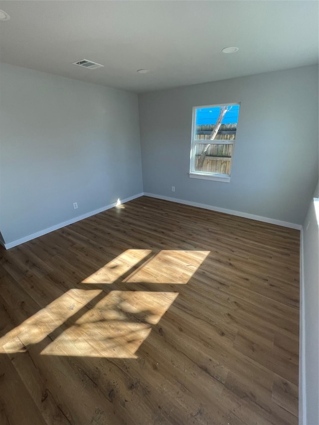 unfurnished room with dark wood-type flooring