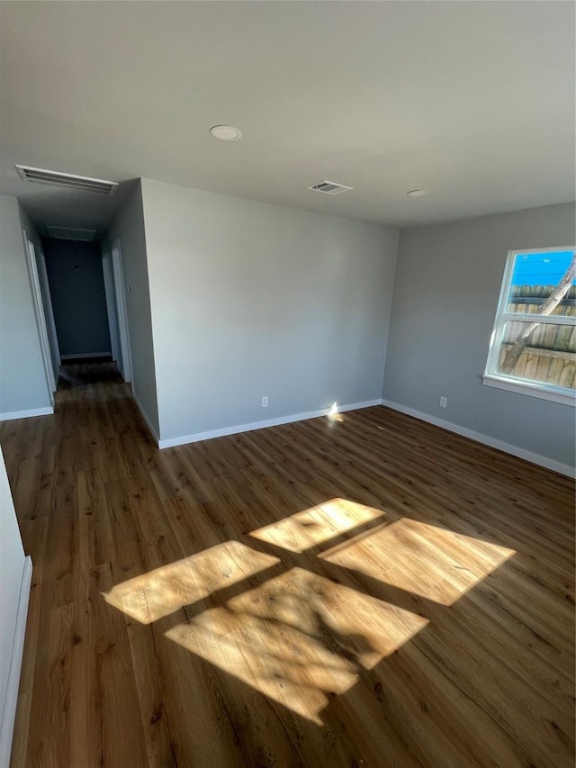 unfurnished room with dark wood-type flooring