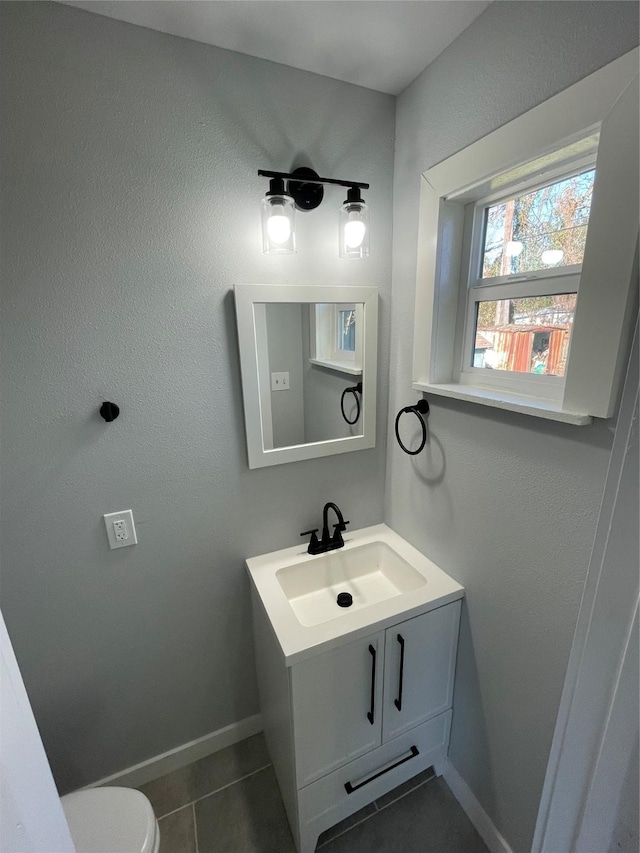 bathroom with toilet, tile patterned flooring, and vanity