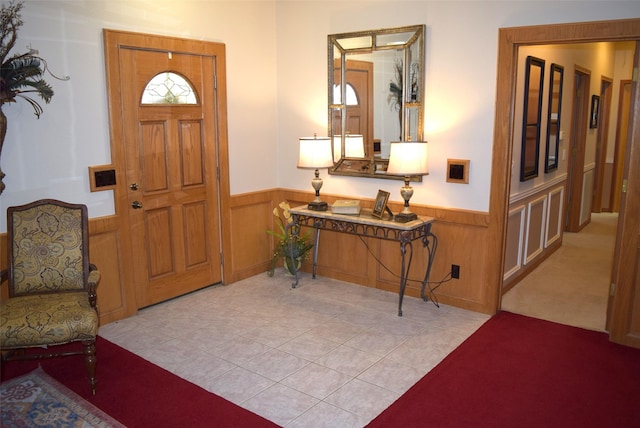 tiled entryway featuring wood walls