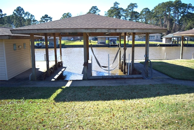 view of dock with a lawn and a water view