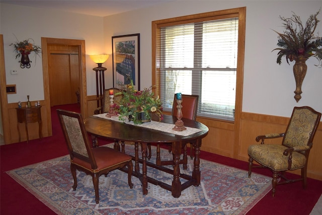 dining space featuring a wealth of natural light and wood walls