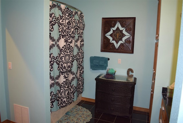 bathroom with tile patterned flooring, vanity, and walk in shower