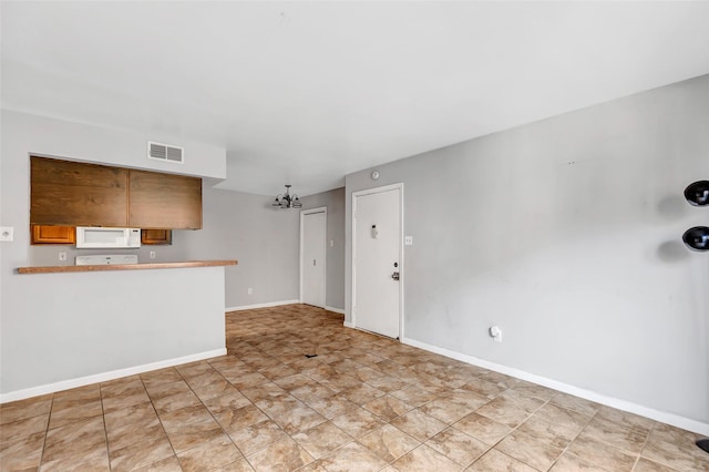 unfurnished living room featuring an inviting chandelier