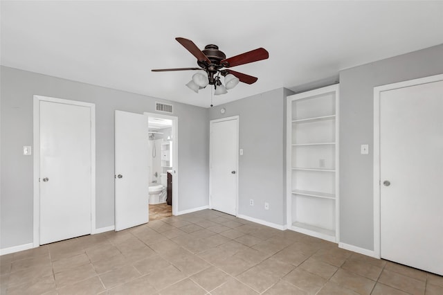 unfurnished bedroom featuring ceiling fan, ensuite bath, and light tile patterned floors