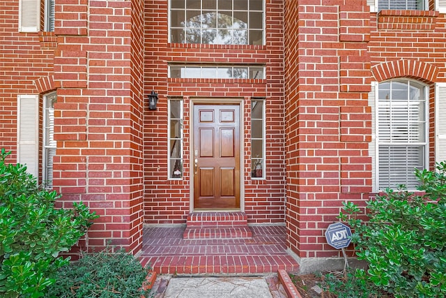 entrance to property featuring brick siding