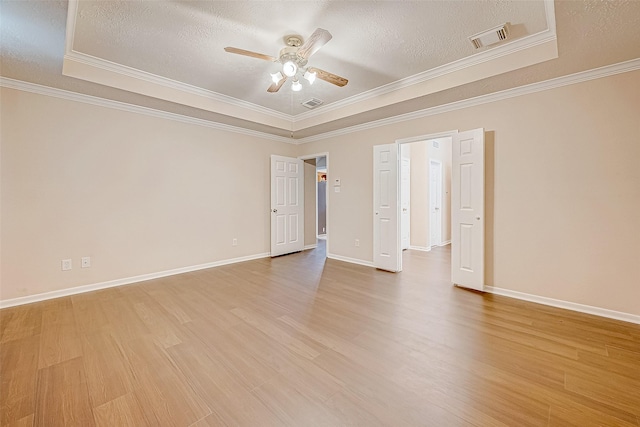 unfurnished room featuring light wood-style floors, crown molding, visible vents, and a textured ceiling