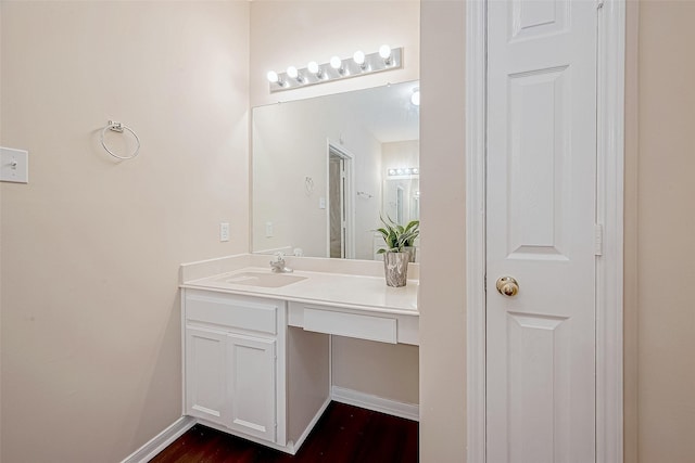 bathroom with vanity, baseboards, and wood finished floors