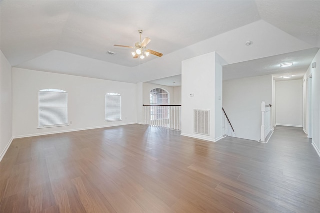 unfurnished living room featuring visible vents, baseboards, and wood finished floors