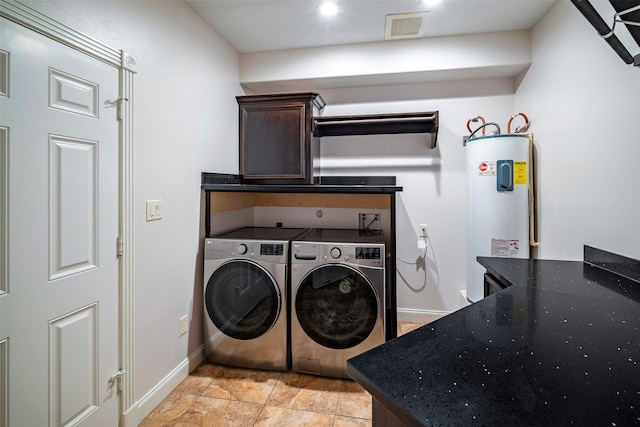 clothes washing area featuring cabinets, separate washer and dryer, and water heater