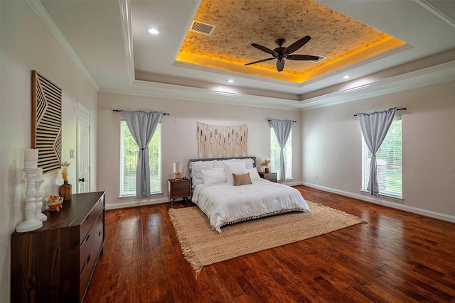 bedroom featuring a raised ceiling, dark hardwood / wood-style flooring, ceiling fan, and crown molding