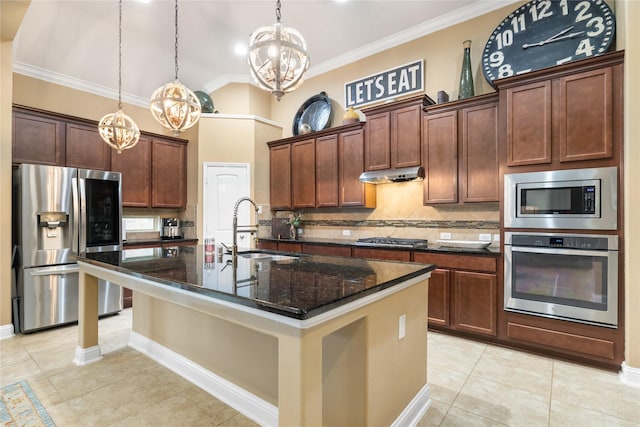 kitchen featuring sink, dark stone countertops, an island with sink, a notable chandelier, and stainless steel appliances