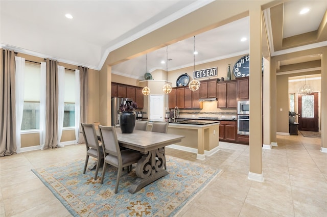 dining space featuring sink, an inviting chandelier, crown molding, and light tile patterned flooring