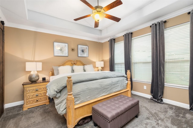 carpeted bedroom featuring a tray ceiling and ceiling fan