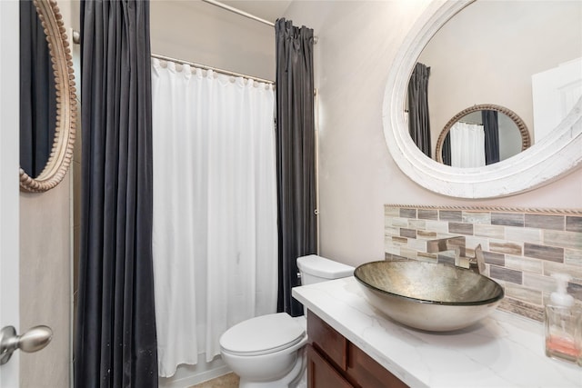 bathroom with vanity, tasteful backsplash, and toilet