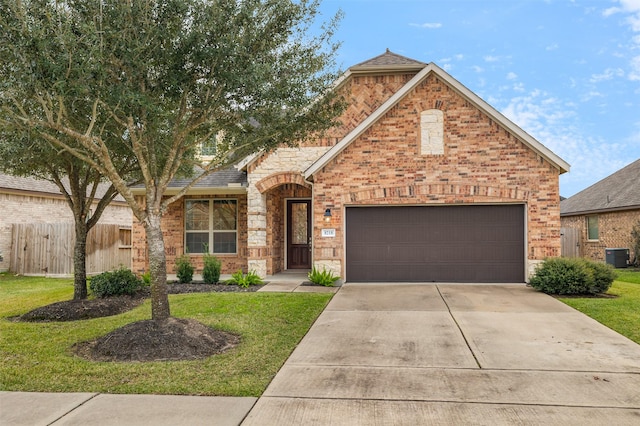 view of front property with central AC, a front yard, and a garage