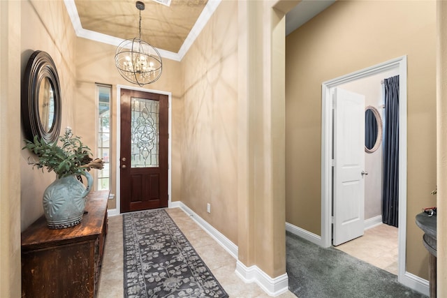 carpeted foyer entrance with crown molding and an inviting chandelier