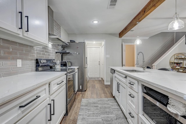 kitchen with white cabinets, decorative light fixtures, sink, and appliances with stainless steel finishes