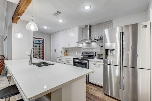 kitchen featuring white cabinets, sink, wall chimney exhaust hood, and appliances with stainless steel finishes