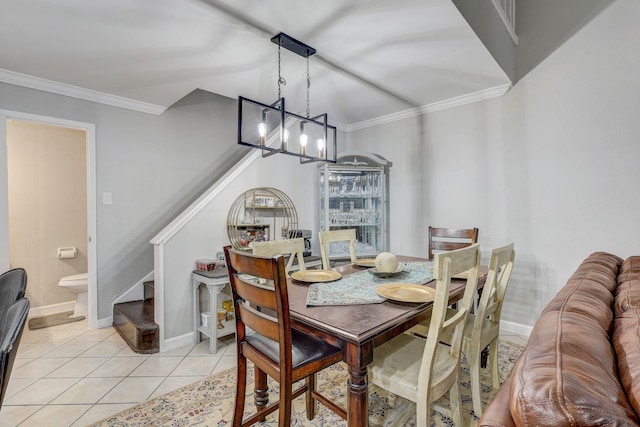 tiled dining room featuring ornamental molding and a chandelier