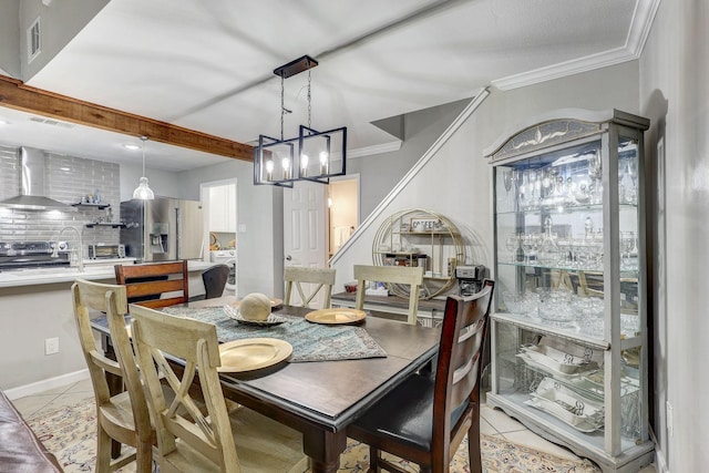 tiled dining space featuring a chandelier and ornamental molding