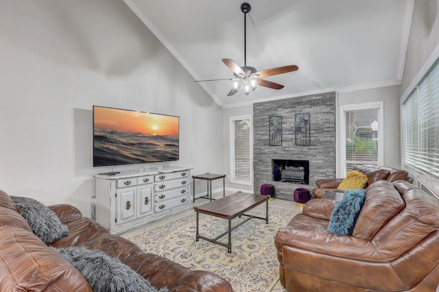 living room featuring ornamental molding, a stone fireplace, ceiling fan, and lofted ceiling