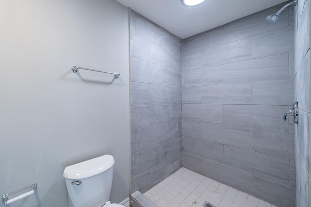 bathroom featuring tiled shower and toilet