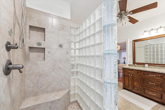 bathroom featuring vanity, ceiling fan, and a tile shower