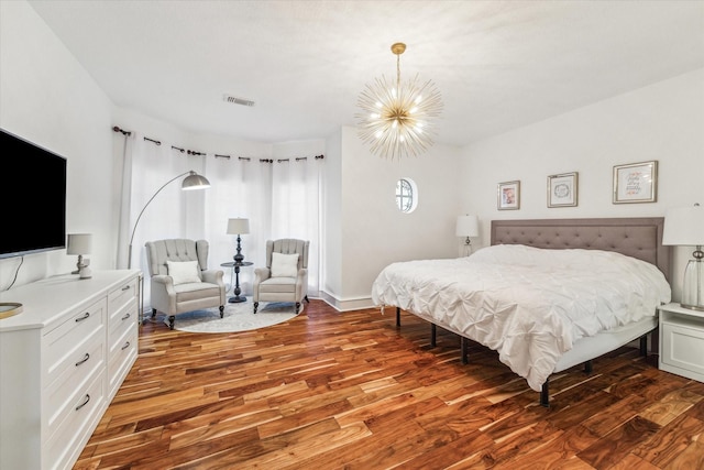 bedroom with dark wood-type flooring and an inviting chandelier