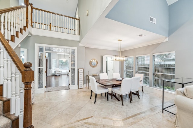 dining space featuring a towering ceiling and a chandelier