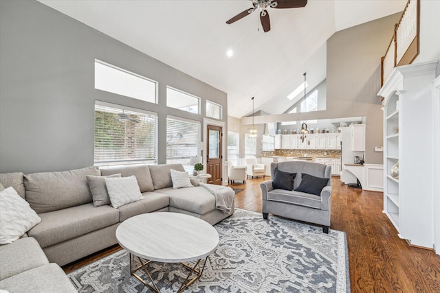 living room with ceiling fan, dark hardwood / wood-style floors, and high vaulted ceiling