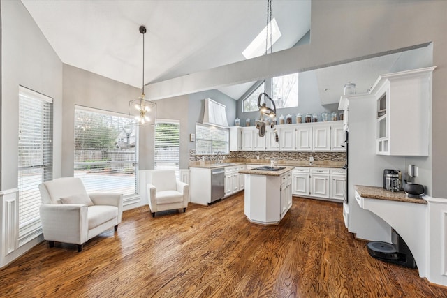 kitchen with backsplash, white cabinets, hanging light fixtures, stainless steel dishwasher, and a kitchen island