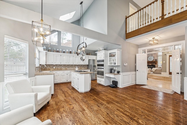 kitchen with pendant lighting, a center island, appliances with stainless steel finishes, tasteful backsplash, and white cabinetry