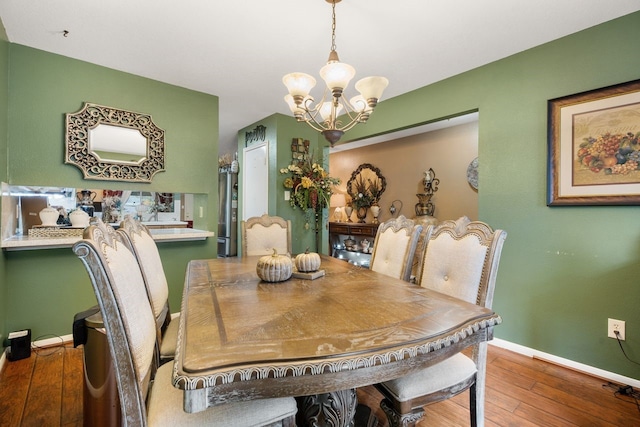 dining room with wood-type flooring and a notable chandelier