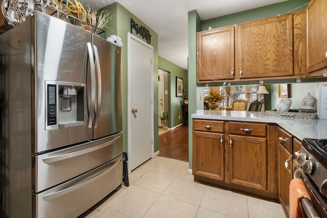 kitchen with kitchen peninsula, light tile patterned floors, and appliances with stainless steel finishes