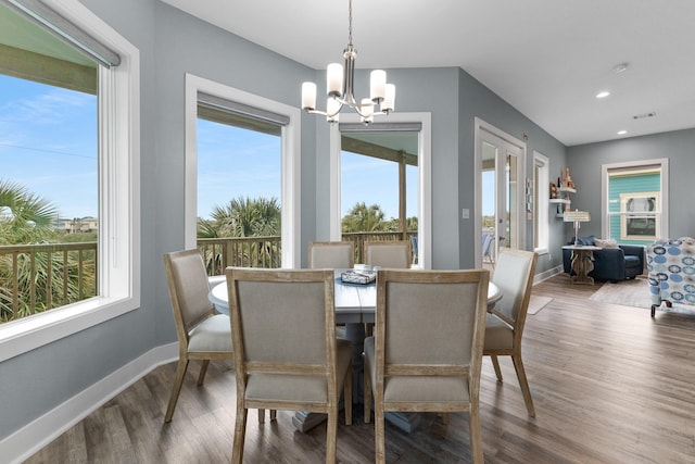 dining space featuring hardwood / wood-style flooring, plenty of natural light, and a notable chandelier