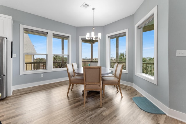 dining room featuring wood-type flooring and an inviting chandelier