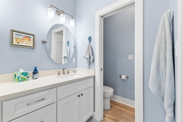 bathroom with hardwood / wood-style flooring, vanity, and toilet