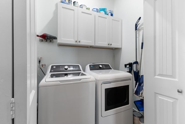 washroom with washer and clothes dryer and cabinets