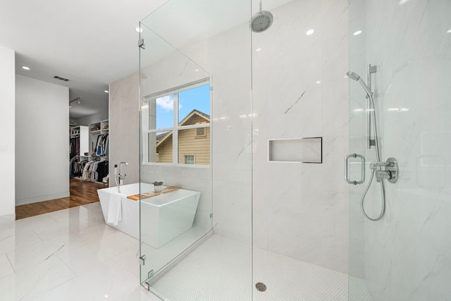 bathroom featuring separate shower and tub