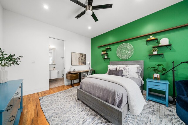 bedroom with ceiling fan, light hardwood / wood-style floors, and ensuite bath